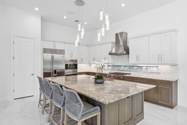 2560 NW 70th Blvd, Boca Raton, FL 33496 - kitchen with wall chimney range hood, white cabinetry, a large island, and appliances with stainless steel finishes