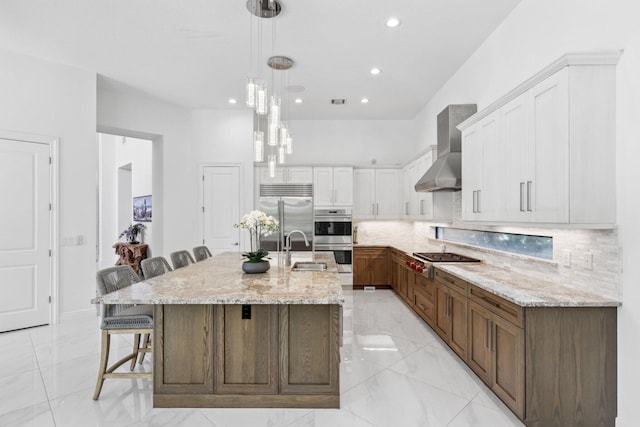 2560 NW 70th Blvd, Boca Raton, FL 33496 - kitchen featuring a breakfast bar area, stainless steel appliances, wall chimney range hood, white cabinets, and backsplash