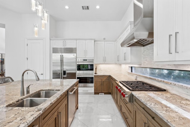 2560 NW 70th Blvd, Boca Raton, FL 33496 - kitchen with brown cabinetry, stainless steel appliances, wall chimney range hood, a sink, and visible vents