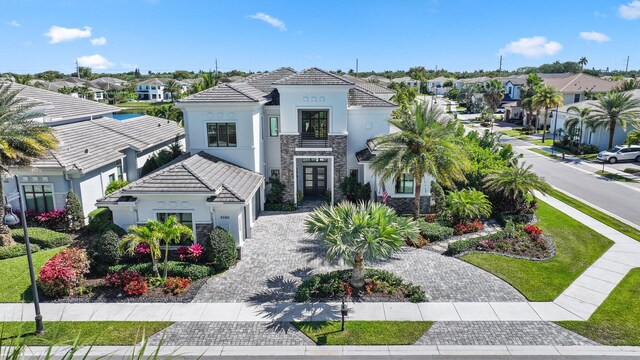 2560 NW 70th Blvd, Boca Raton, FL 33496 - mediterranean / spanish-style home with stucco siding, a tiled roof, a residential view, driveway, and stone siding