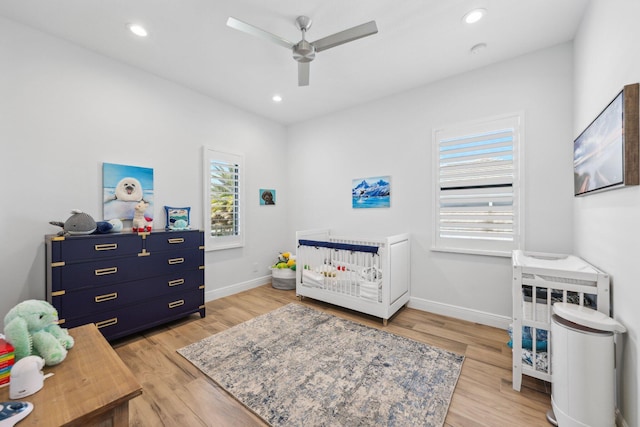2560 NW 70th Blvd, Boca Raton, FL 33496 - bedroom featuring light wood-style floors, recessed lighting, a nursery area, and baseboards