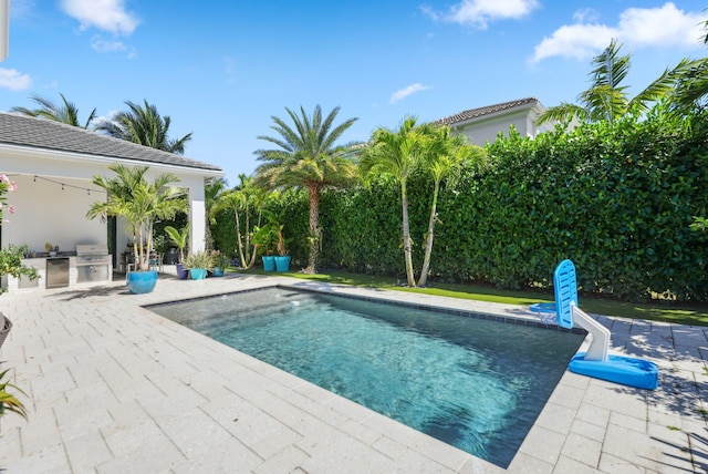 2560 NW 70th Blvd, Boca Raton, FL 33496 - view of pool with a grill, exterior kitchen, a patio, and a fenced in pool