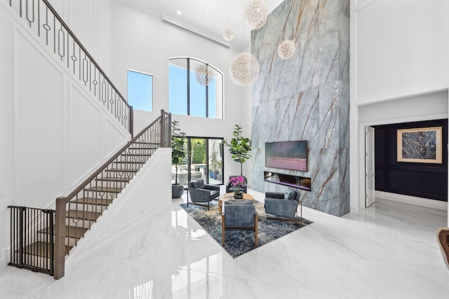 2560 NW 70th Blvd, Boca Raton, FL 33496 - living room with a tile fireplace, a high ceiling, marble finish floor, and stairs