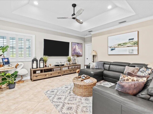tiled living area featuring a ceiling fan, visible vents, crown molding, a tray ceiling, and recessed lighting