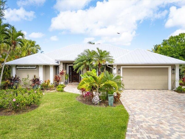 single story home with a garage, stucco siding, driveway, and a front yard