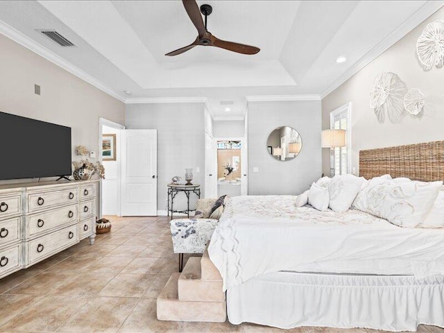bedroom featuring visible vents, connected bathroom, crown molding, and a tray ceiling