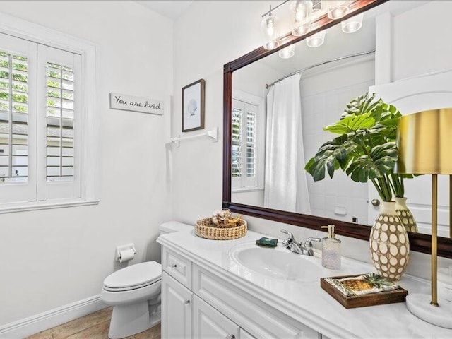 bathroom with vanity, baseboards, and toilet