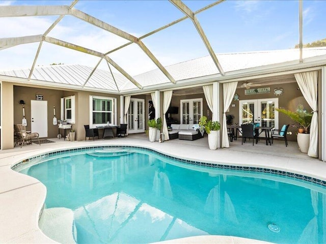 outdoor pool featuring a patio, a lanai, french doors, and an outdoor hangout area