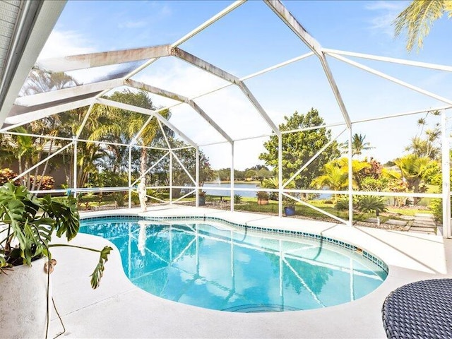 outdoor pool with glass enclosure and a patio area