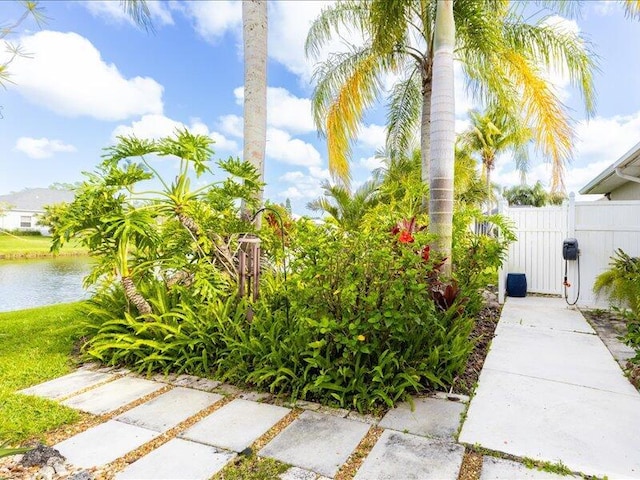 view of yard featuring a gate, fence, and a water view