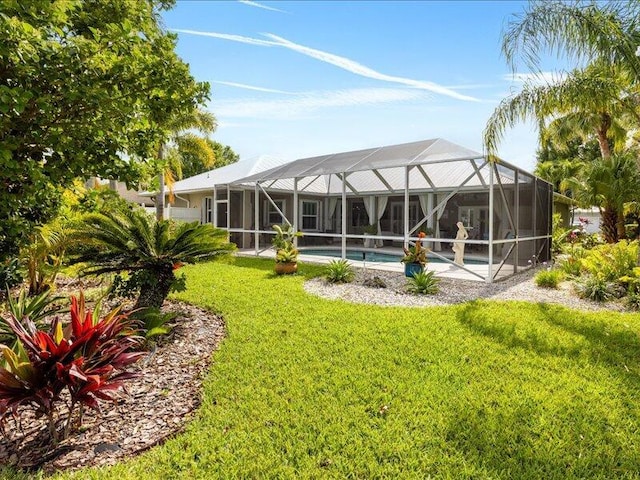 rear view of house with a yard and an outdoor pool