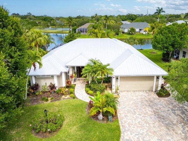 view of front of house featuring a water view, an attached garage, driveway, and a front lawn