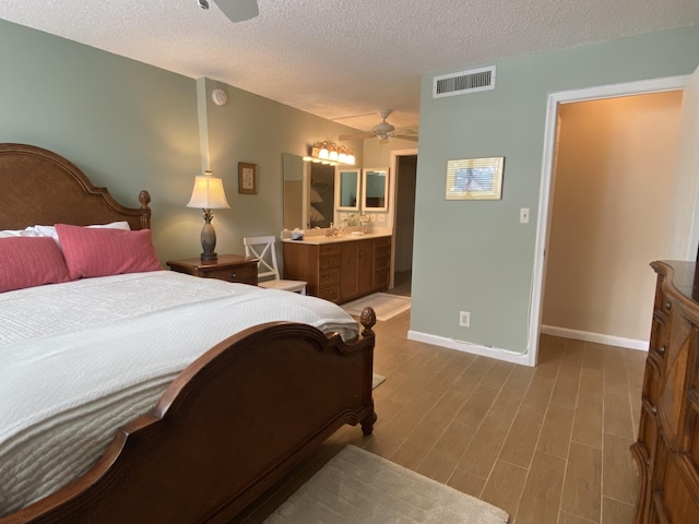 7 Royal Palm Way Unit 202, Boca Raton, FL 33432 - bedroom with a textured ceiling, wood finished floors, ceiling fan, and ensuite bath