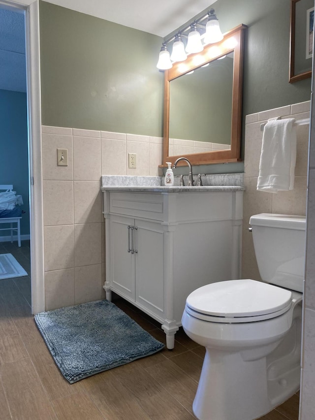 7 Royal Palm Way Unit 202, Boca Raton, FL 33432 - bathroom featuring tile walls, vanity, wood finished floors, and wainscoting