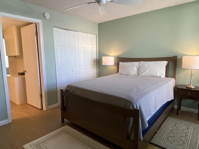 7 Royal Palm Way Unit 202, Boca Raton, FL 33432 - bedroom with wood finished floors, a closet, a textured ceiling, and a ceiling fan