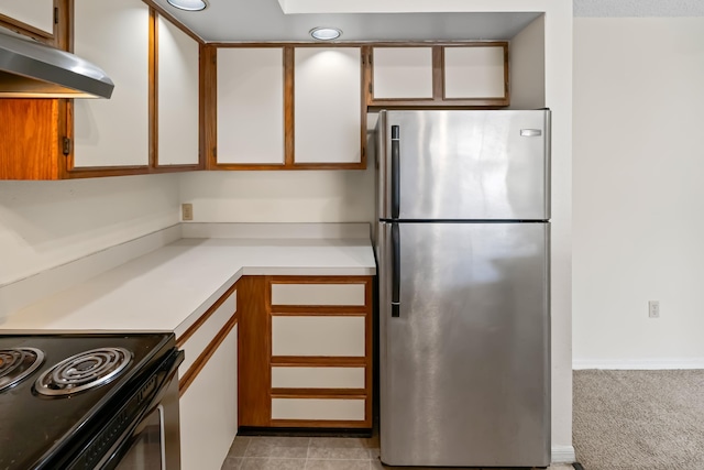kitchen with white cabinets, light countertops, freestanding refrigerator, under cabinet range hood, and recessed lighting