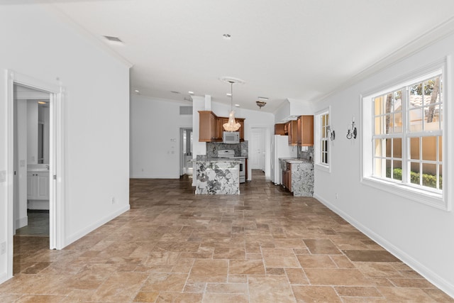 kitchen with white appliances, brown cabinetry, stone finish flooring, tasteful backsplash, and ornamental molding