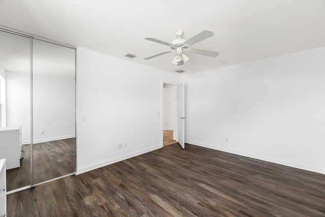 unfurnished bedroom with a ceiling fan, baseboards, wood finished floors, visible vents, and a closet