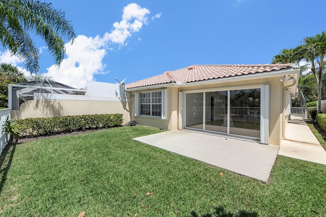 rear view of house featuring stucco siding, a fenced backyard, a patio area, a tiled roof, and a yard
