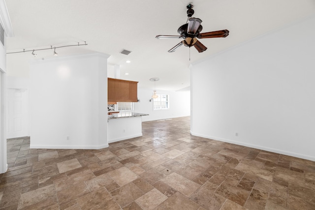unfurnished living room with crown molding, visible vents, a ceiling fan, and stone tile floors