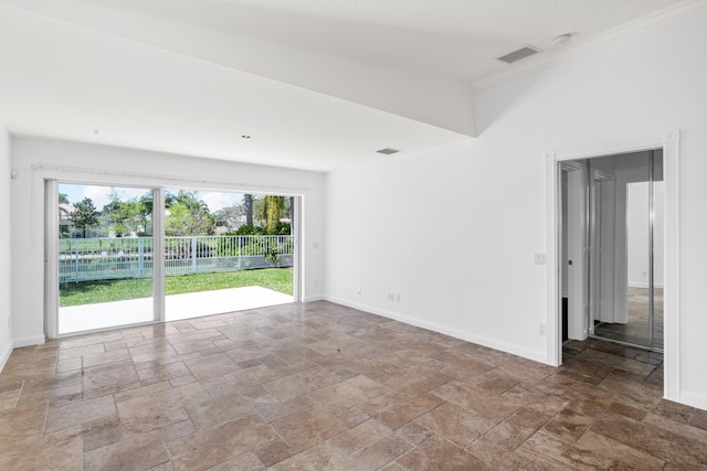 spare room featuring crown molding, baseboards, visible vents, and stone tile flooring