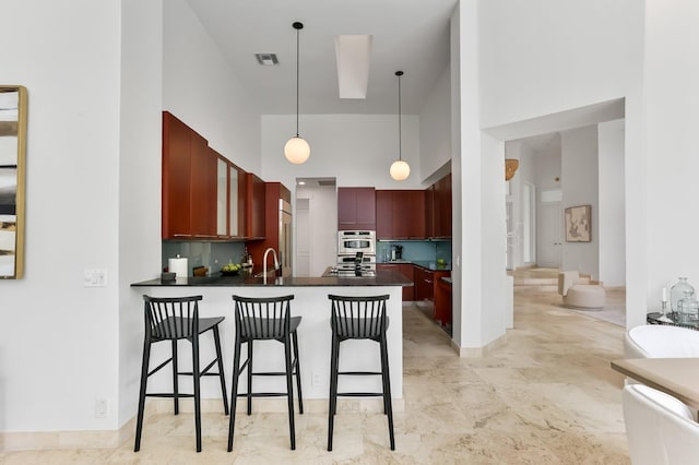 6247 NW 33rd Ave, Boca Raton, FL 33496 - kitchen featuring dark countertops, a high ceiling, reddish brown cabinets, and a sink