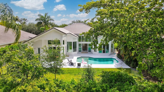 6247 NW 33rd Ave, Boca Raton, FL 33496 - back of property featuring stucco siding, an outdoor pool, a patio area, and a lawn