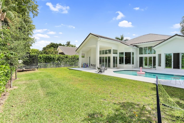6247 NW 33rd Ave, Boca Raton, FL 33496 - rear view of house with a fenced in pool, fence, a trampoline, a yard, and a patio