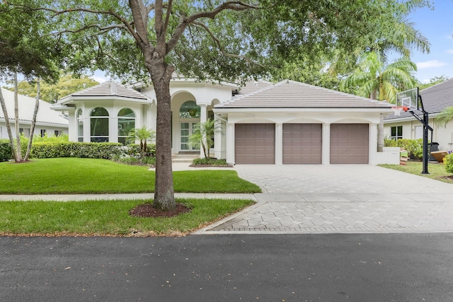 6247 NW 33rd Ave, Boca Raton, FL 33496 - view of front facade with a tile roof, a front lawn, a garage, stucco siding, and decorative driveway