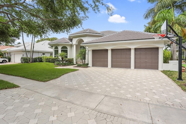 6247 NW 33rd Ave, Boca Raton, FL 33496 - mediterranean / spanish-style home with a tile roof, driveway, a garage, a front yard, and stucco siding