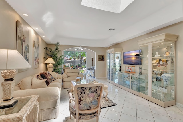 living area with tile patterned floors, visible vents, a tray ceiling, and recessed lighting