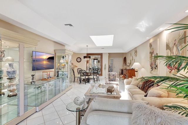 living area featuring light tile patterned floors, visible vents, recessed lighting, and a skylight