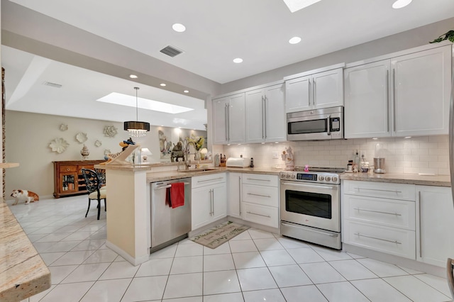 kitchen featuring a sink, visible vents, a peninsula, a skylight, and appliances with stainless steel finishes