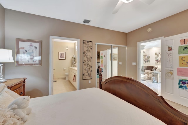 bedroom with visible vents, a ceiling fan, and ensuite bath