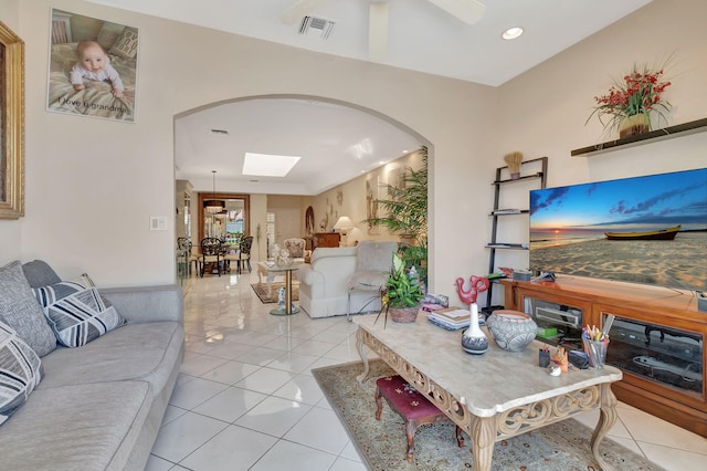 tiled living area with recessed lighting, a skylight, a ceiling fan, visible vents, and arched walkways