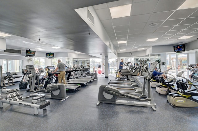 exercise room with visible vents, a drop ceiling, and plenty of natural light