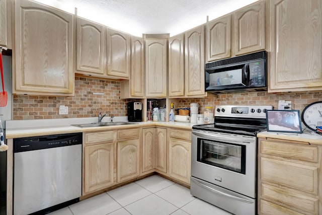 kitchen with decorative backsplash, a sink, light countertops, light brown cabinets, and stainless steel appliances