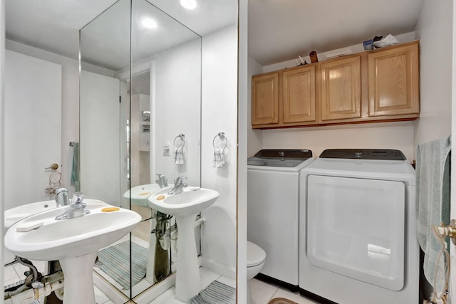 bathroom with tile patterned flooring, washer and clothes dryer, and toilet