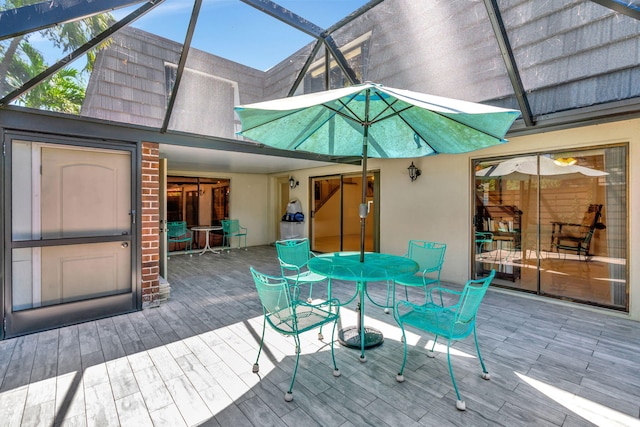 wooden terrace with glass enclosure and outdoor dining space