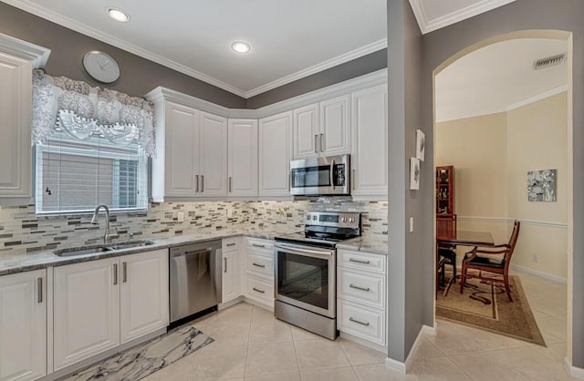 kitchen with stainless steel appliances, visible vents, a sink, light tile patterned flooring, and white cabinetry