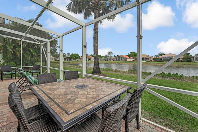 sunroom / solarium featuring outdoor dining area and a water view