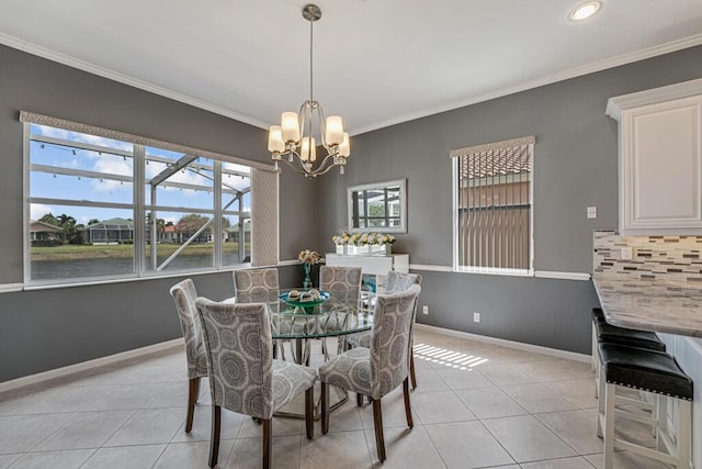 dining room with a water view, light tile patterned floors, an inviting chandelier, baseboards, and ornamental molding