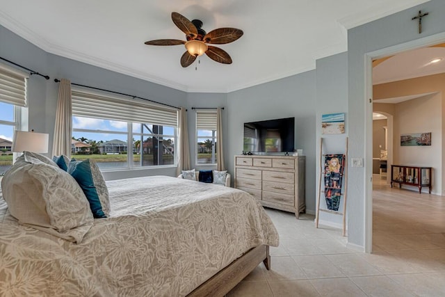 bedroom with a ceiling fan, crown molding, light tile patterned flooring, arched walkways, and baseboards