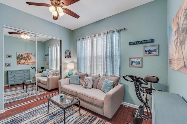 living room featuring wood finished floors, a ceiling fan, and baseboards