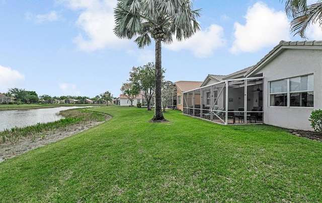 view of yard with a lanai and a water view