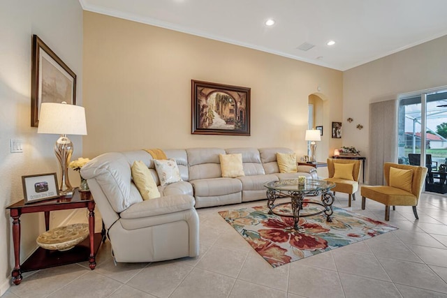 tiled living area featuring baseboards, arched walkways, ornamental molding, and recessed lighting