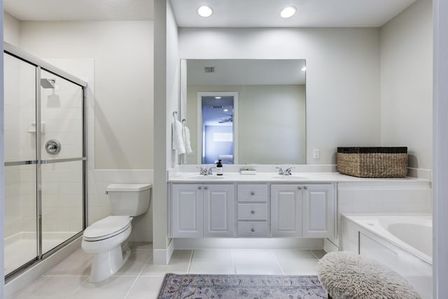 full bathroom featuring tile patterned flooring, double vanity, toilet, a sink, and a stall shower