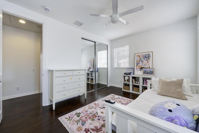 bedroom with baseboards, visible vents, wood finished floors, and a closet
