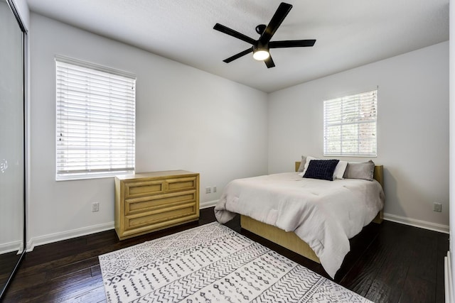 bedroom with baseboards, ceiling fan, and dark wood-type flooring
