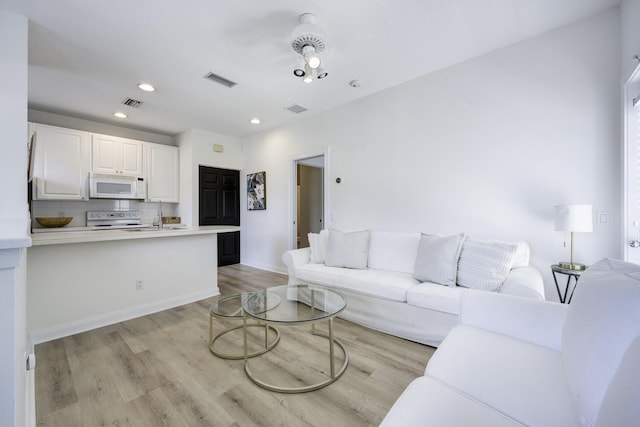 living area featuring visible vents, recessed lighting, and light wood finished floors